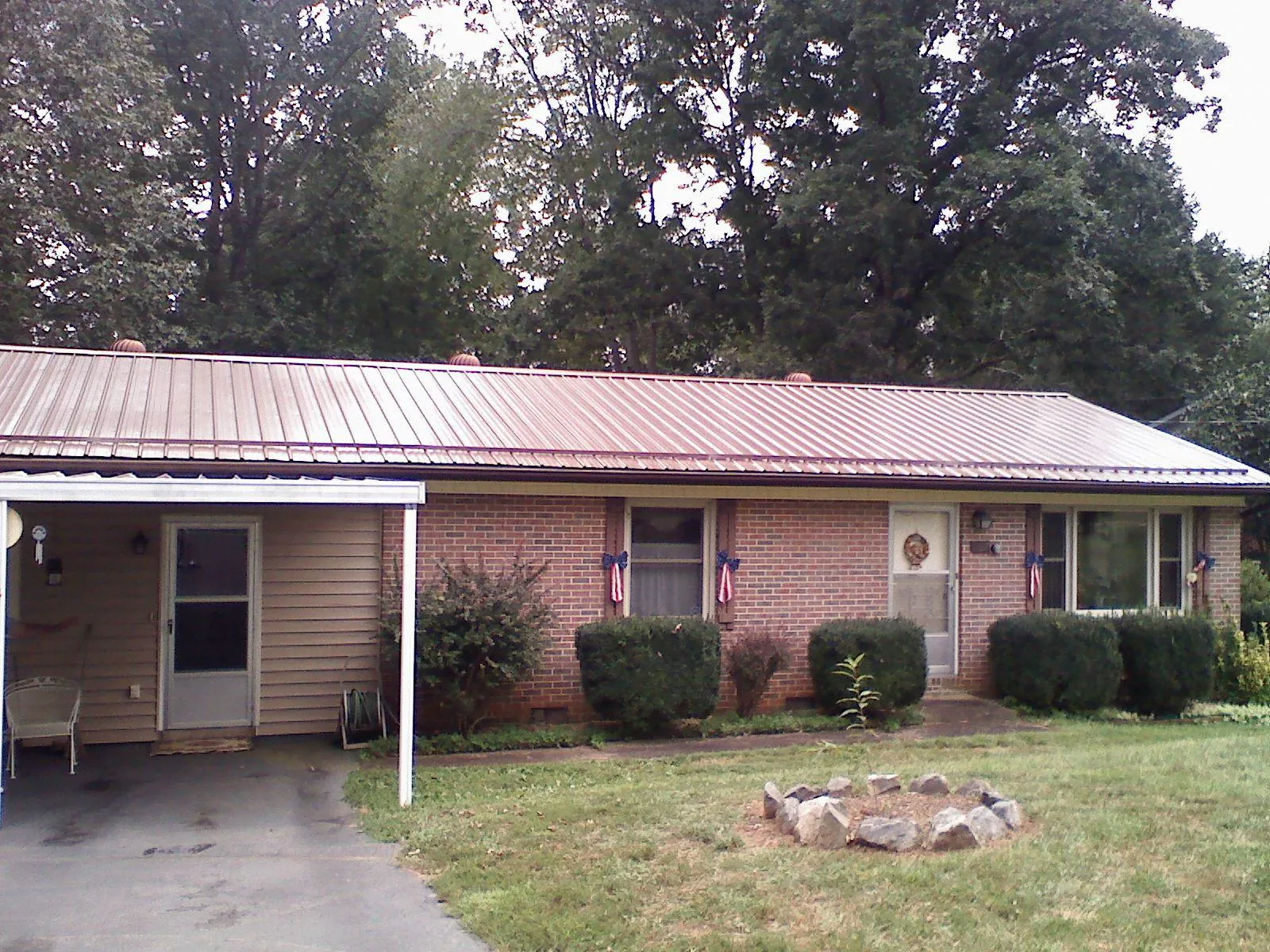 Bronze metal roof and carport on a brick ranch home — Roof Repair work by our crew in Healdton